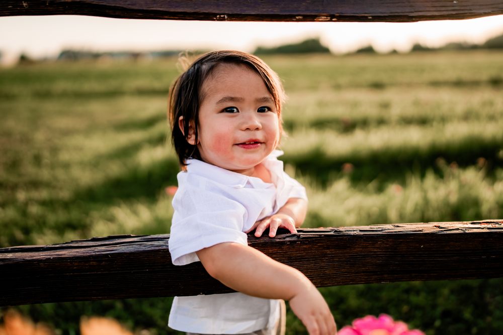 Little one enjoying outdoor playtime on a rustic wooden bench at sunset.