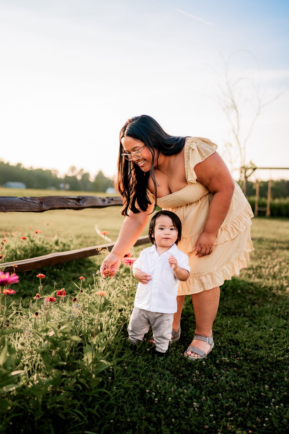 A heartwarming moment in a wildflower field as a parent and child explore nature together at sunset.