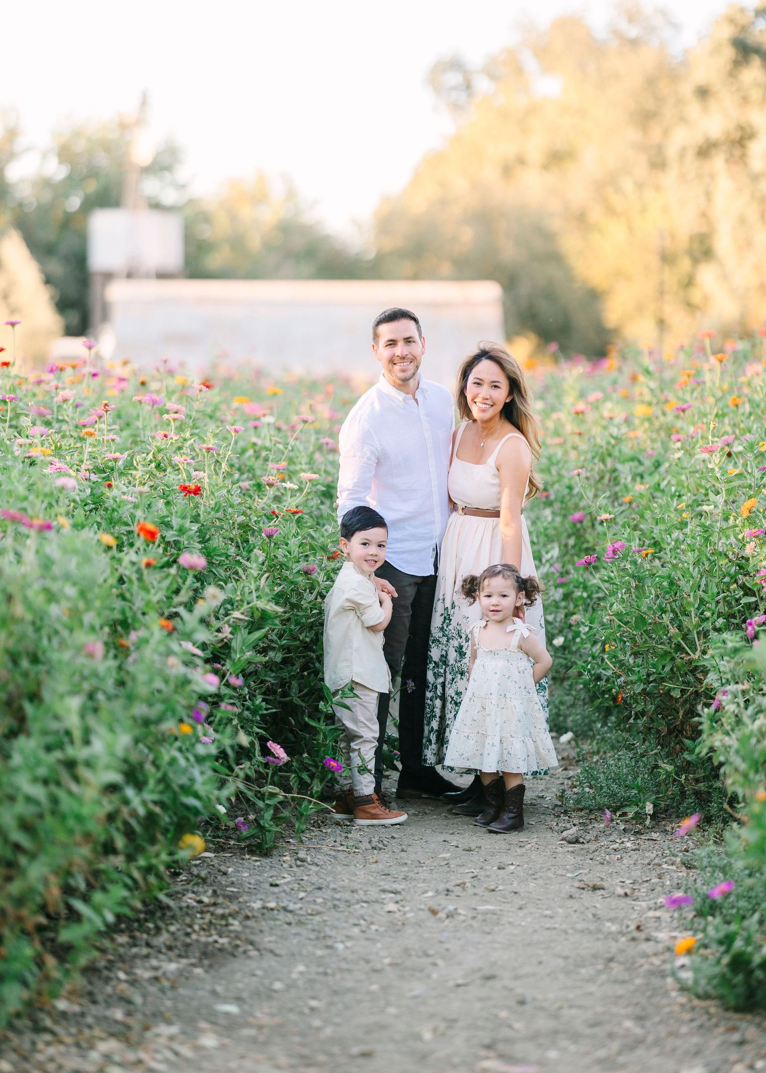 Family photo session captured among blooming wildflowers at golden hour.