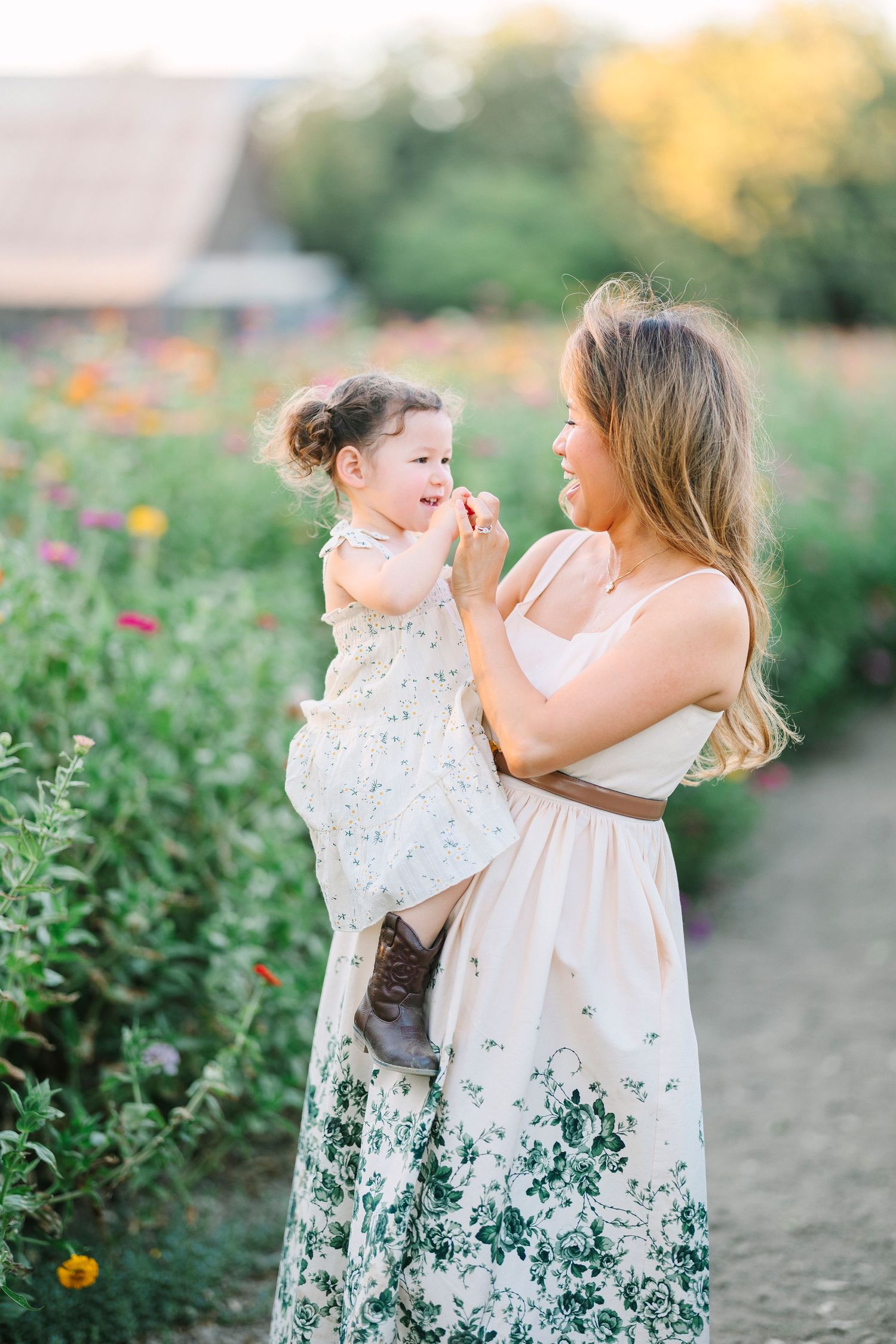 Family members share tender moments among blooming garden flowers at sunset.