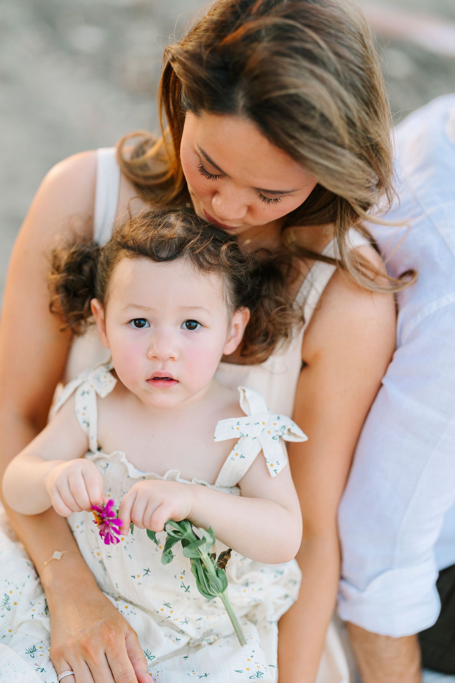An intimate moment captured between two people holding flowers outdoors.