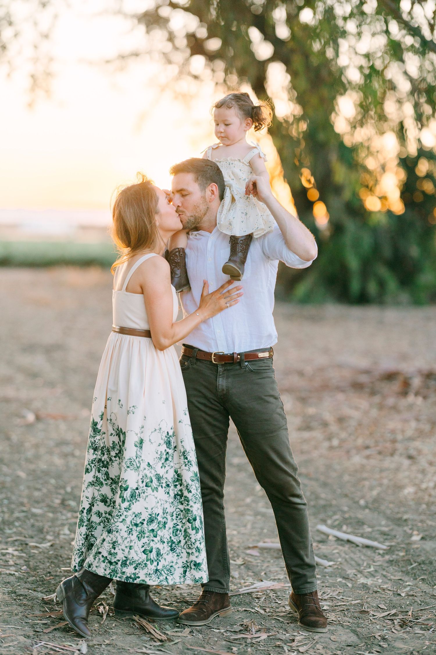 A romantic moment shared between three people against a golden sunset backdrop.