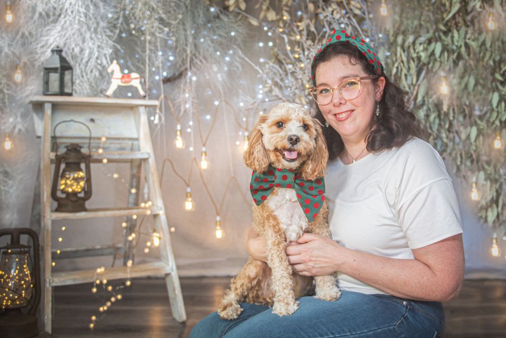 Dogs and companions gather for Christmas photos with sparkling lights and decorative elements.