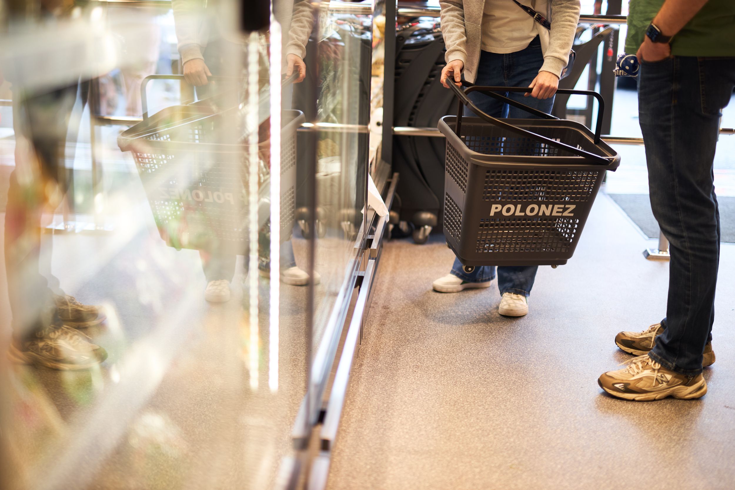 Blurred view of customers walking through retail store aisle.