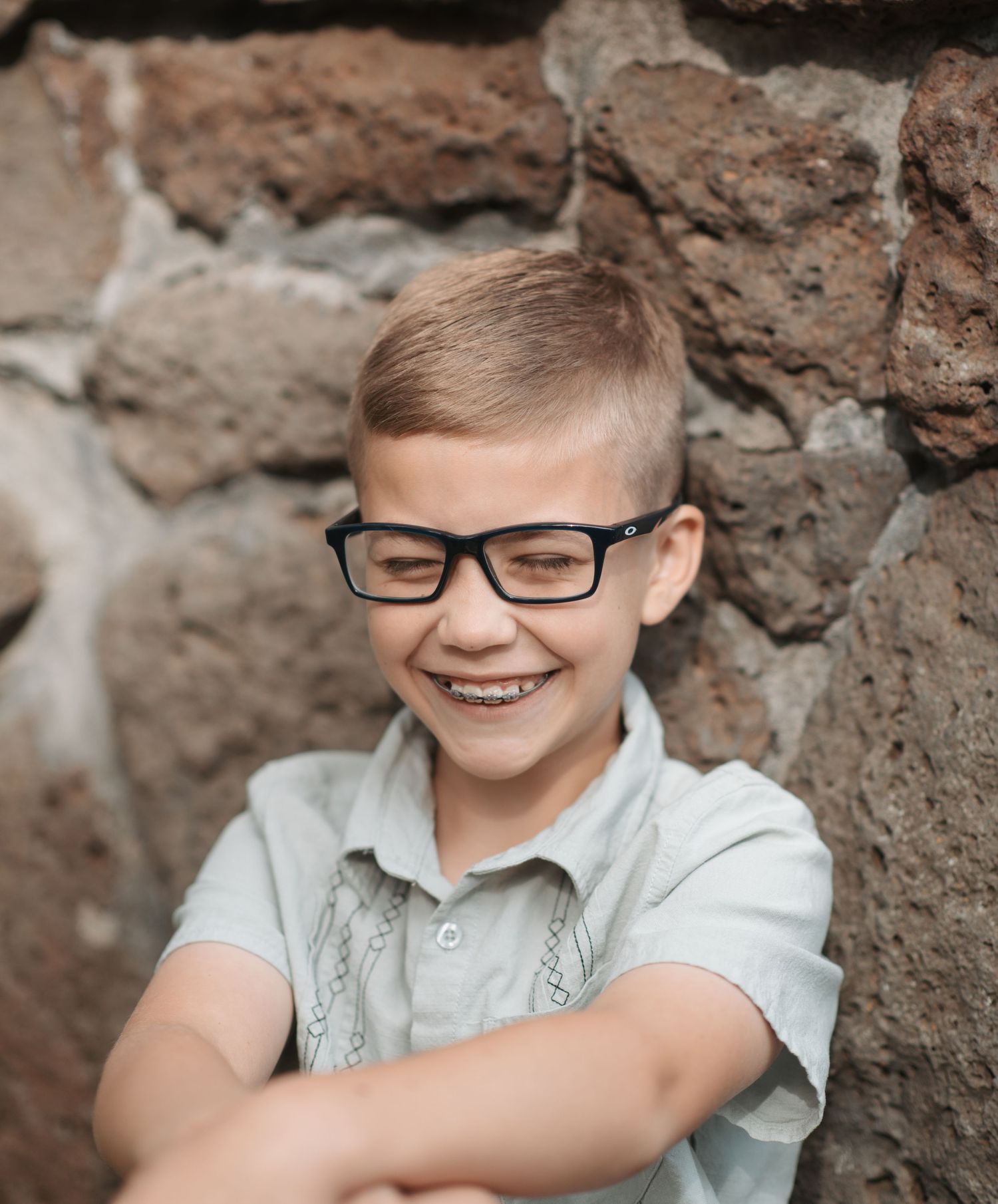 Little boy with glasses laughing during a family photo session in Spokane, Washington.