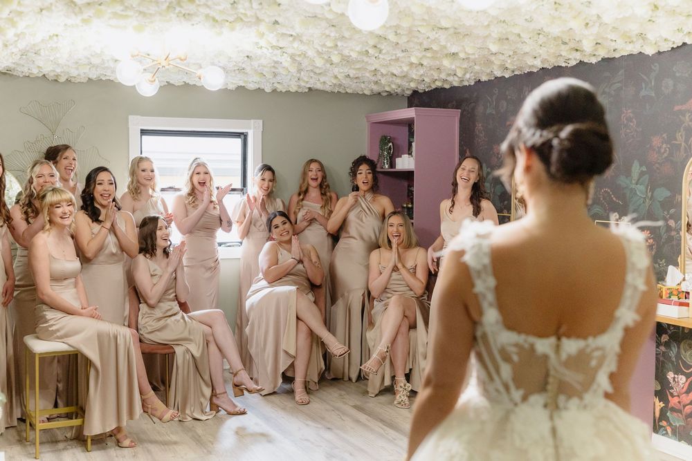 Bridesmaids in blush dresses reacting joyfully during a wedding celebration.