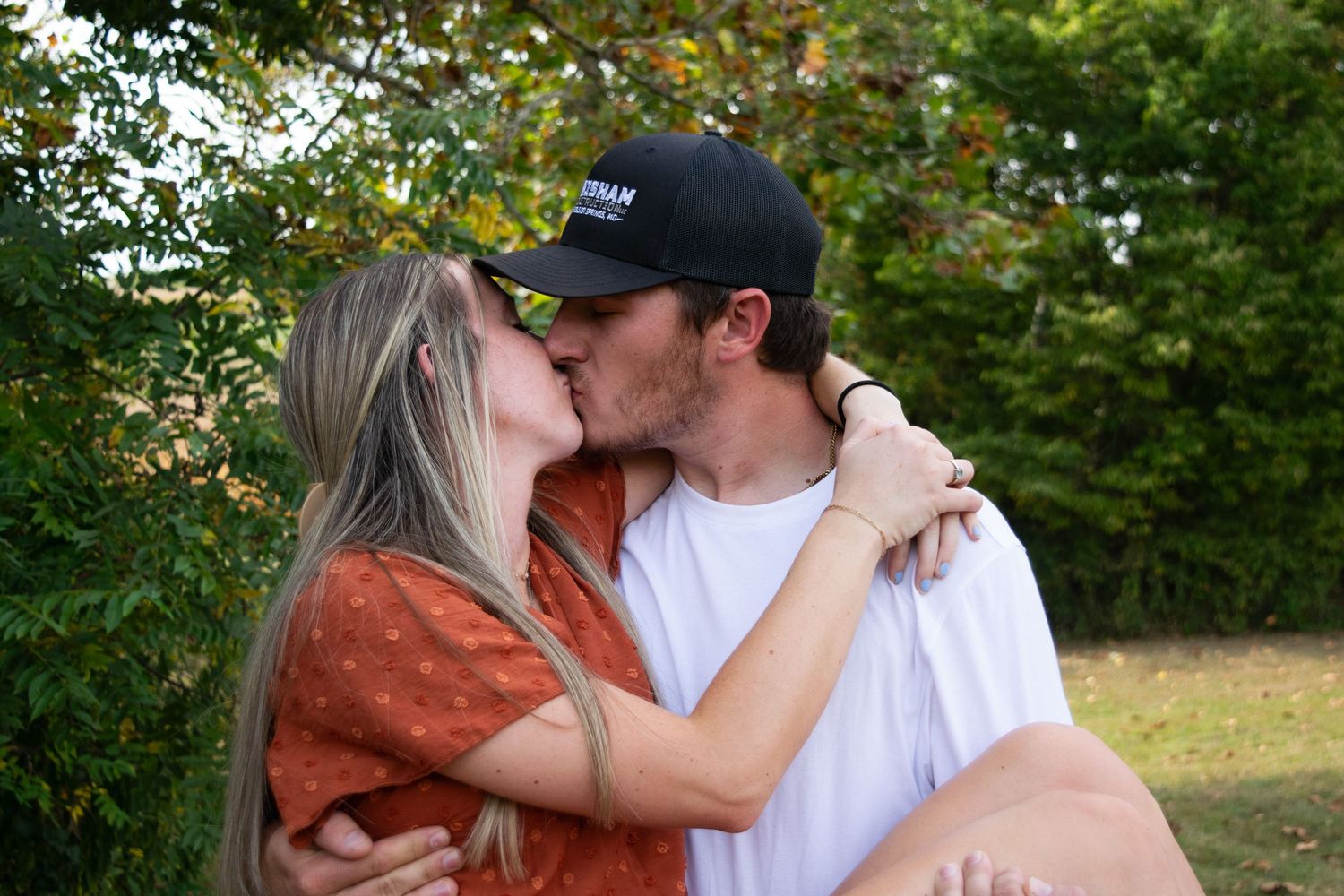 Man carrying woman while they are kissing
