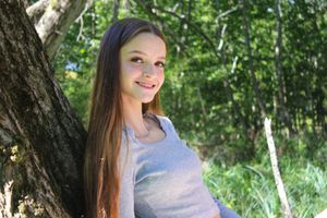 Someone relaxes in a natural forest setting wearing casual summer clothing.