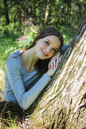 Artistic nature portrait showing relaxed pose against textured tree bark.