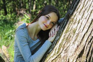 Dreamy woodland portrait with soft natural lighting filtering through trees.