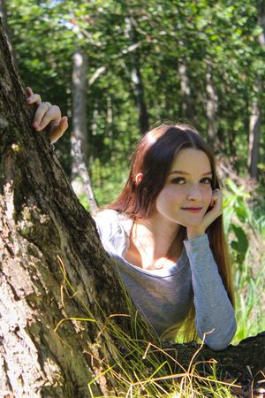 Natural outdoor portrait with dappled sunlight through forest canopy.