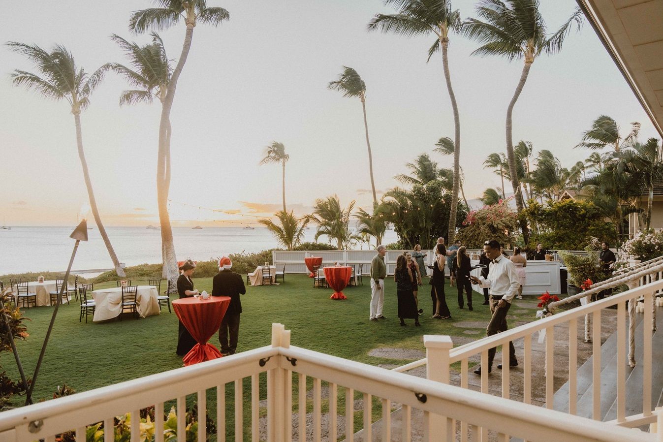 MWEA celebration at Sugar Beach venue palm trees swaying in the wind along a beachfront property with white railings on Maui, Hawaii
