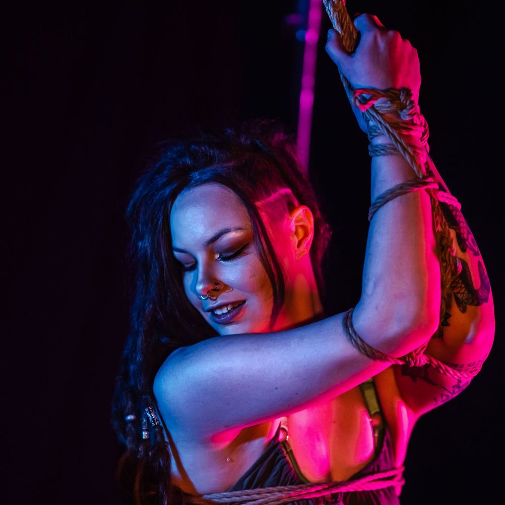 Ten artistic boudoir photos with dramatic red and blue lighting show a sensual silhouette against dark background.