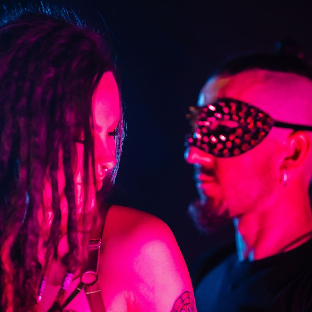Artistic portrait in neon lighting showcasing vibrant pink and blue tones creating a dramatic nightclub atmosphere.