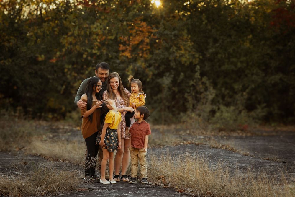 A golden sunset illuminates a rustic autumn outdoor setting with tall grass and trees.