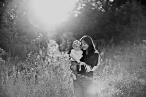 A couple shares tender moments in a sunlit meadow during a black and white outdoor photoshoot.