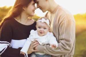 A family shares tender moments together on a sunny evening with golden light in the background.
