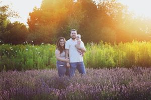 A family standing in a lavender field during golden sunset.