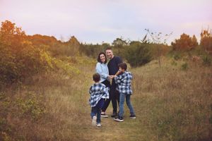 A family walking together through a rustic field during sunset.