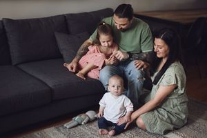 A series of connected lifestyle photos showing intimate family moments relaxing together on a couch and carpet.