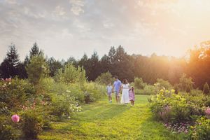 A couple walking through a lush garden path at golden hour.