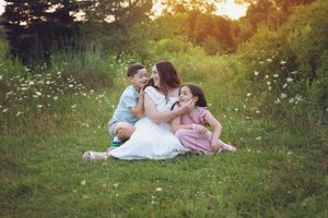A loving family moment captured in a wildflower meadow at dusk.