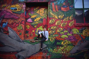 Vibrant street art mural featuring colorful creatures and designs creates an urban backdrop.