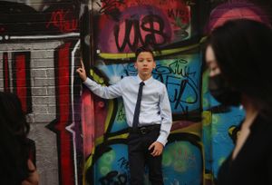 Urban photography session against a wall covered in colorful graffiti art.