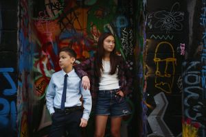 Modern urban portrait session against graffiti-covered wall in an alley setting.