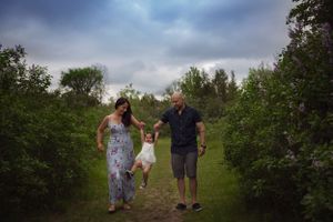 Family walking together on a nature path under dramatic cloudy skies.