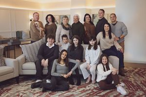 Large multigenerational family posing together in a cozy living room for a group portrait photo.
