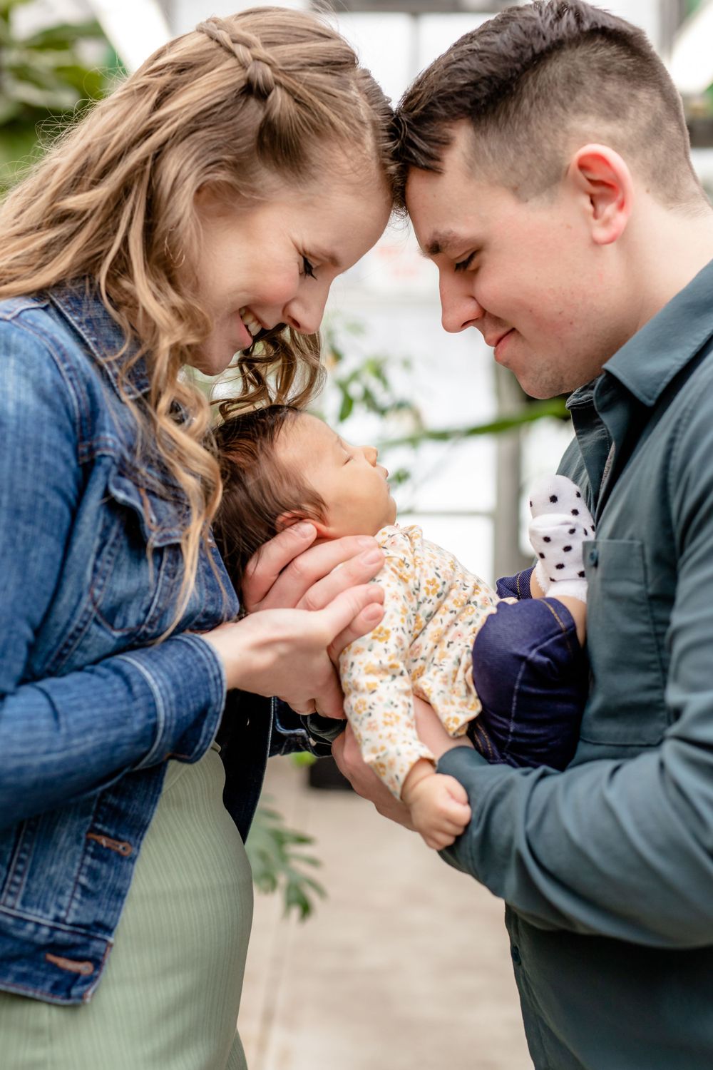 An intimate family moment shared between parents and their baby outdoors.