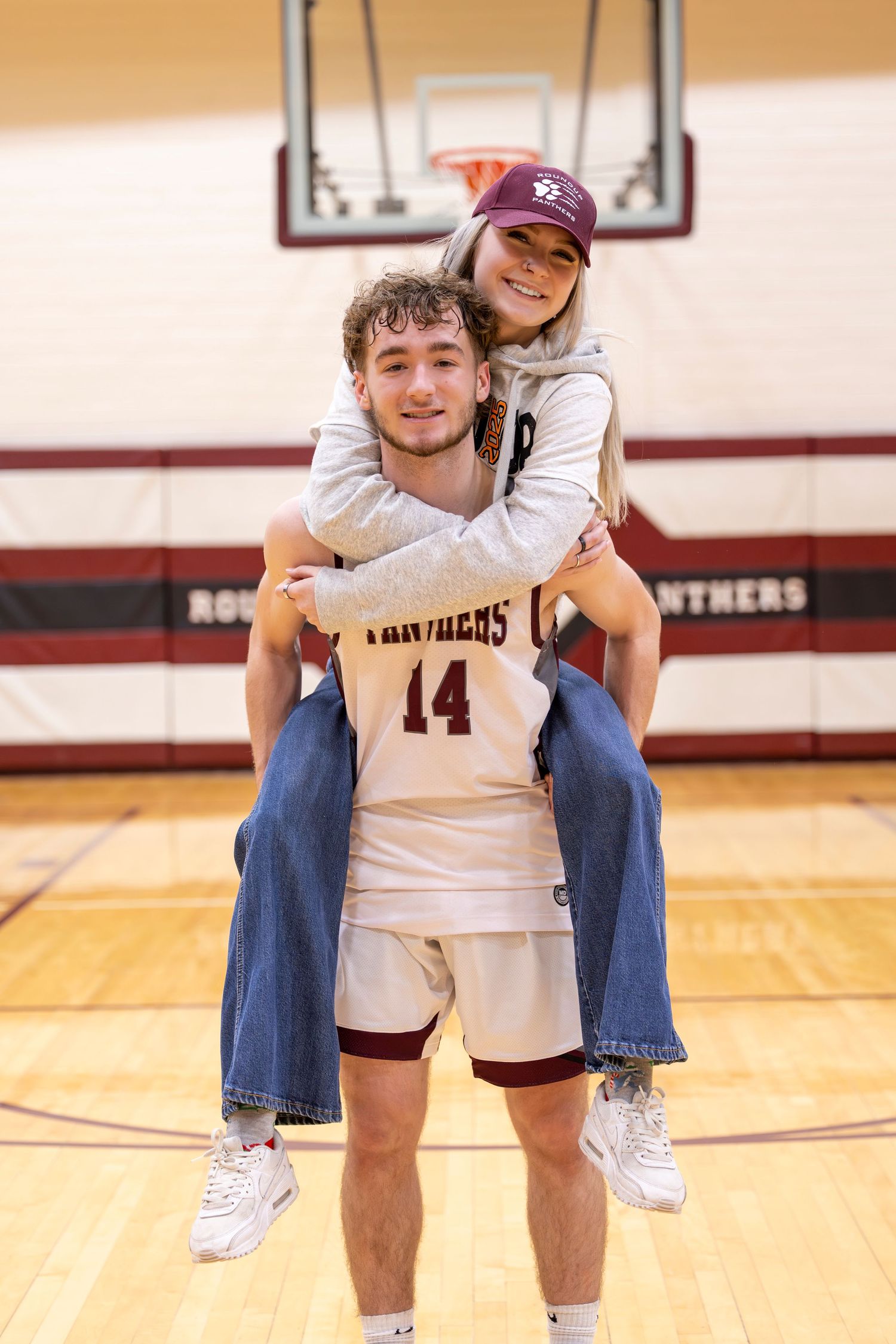 Couple having there picture taken to preserve there last hometown basketball game together.