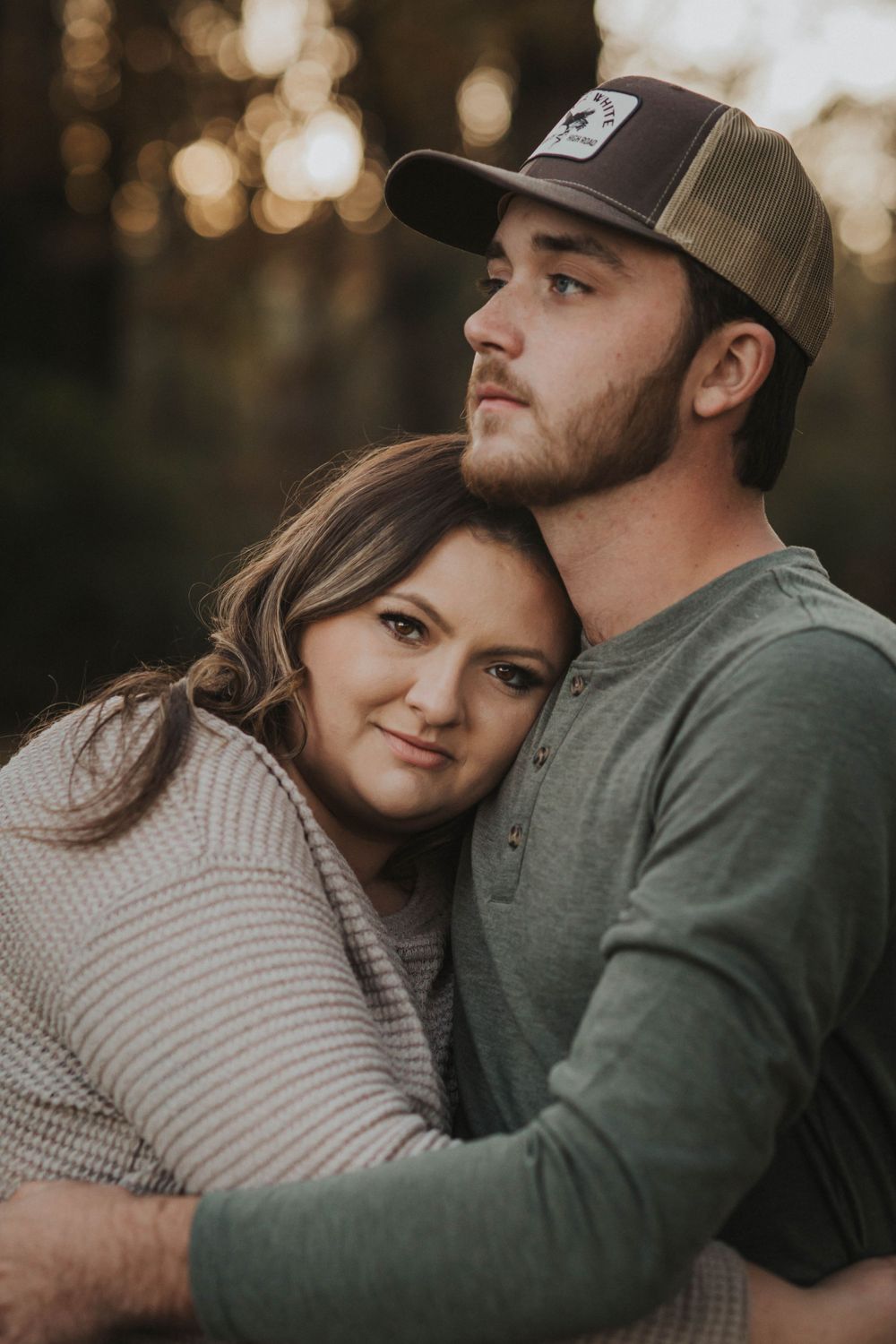 Cozy autumn couple portrait with soft bokeh lighting in the background.