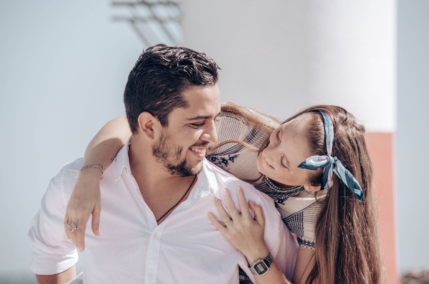 Romantic young couple sharing a tender moment, almost kissing outdoors in natural light.
