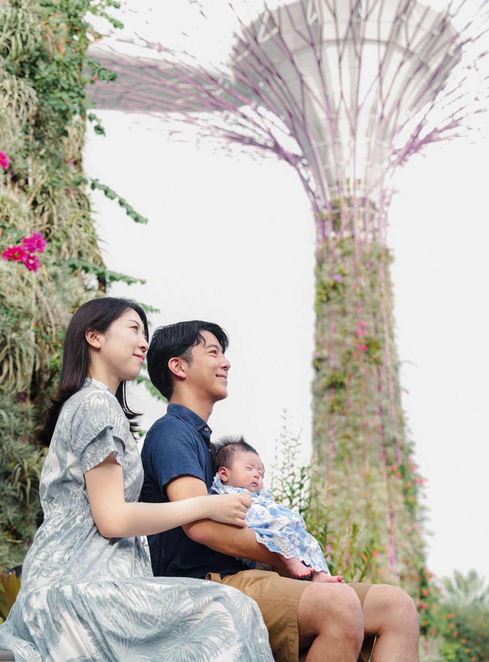 Family enjoys a moment together against the backdrop of Singapore's iconic Supertree Grove at Gardens by the Bay.