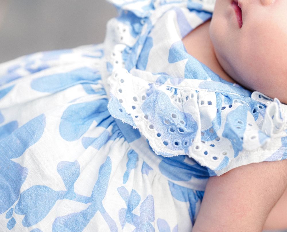 Close-up view of white lace trim detail on a light blue and white heart patterned fabric.