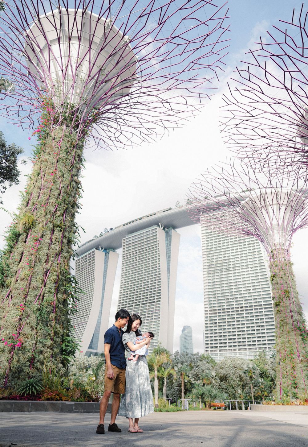 Iconic Supertree Grove and Marina Bay Sands hotel tower in Singapore's Gardens by the Bay on a cloudy day.