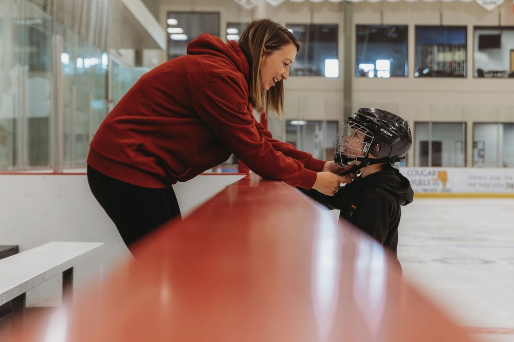 A sequence of five photos showing someone tying ice skates at an indoor ice rink.