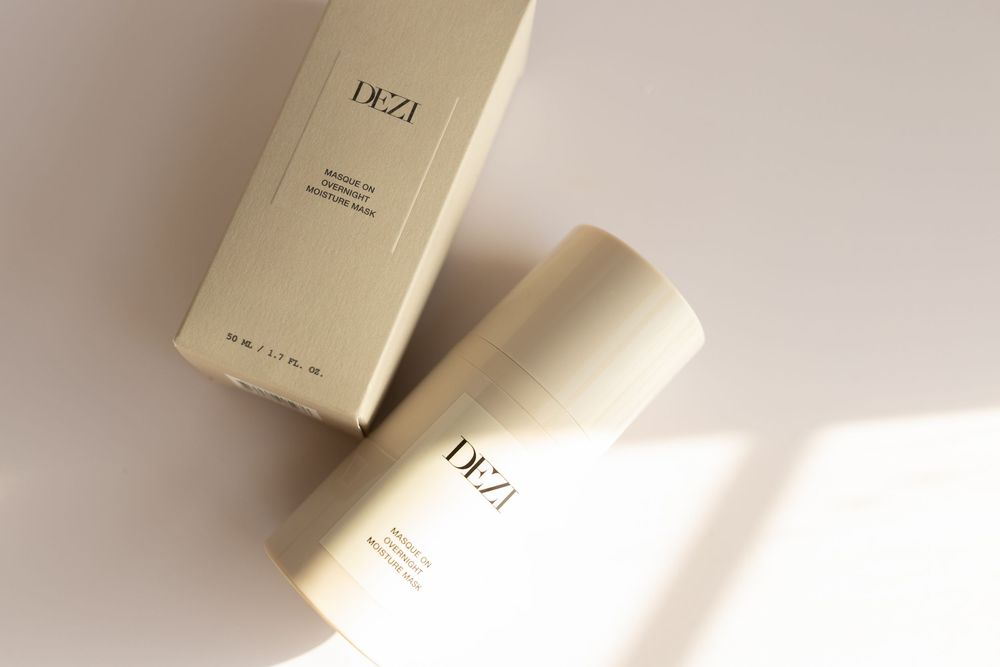 White beauty product containers and boxes arranged on a light beige surface in minimalist style.