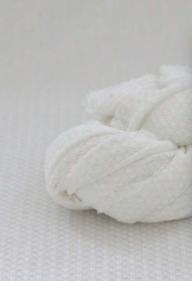 White textured fabric or blanket material shown in close-up detail.