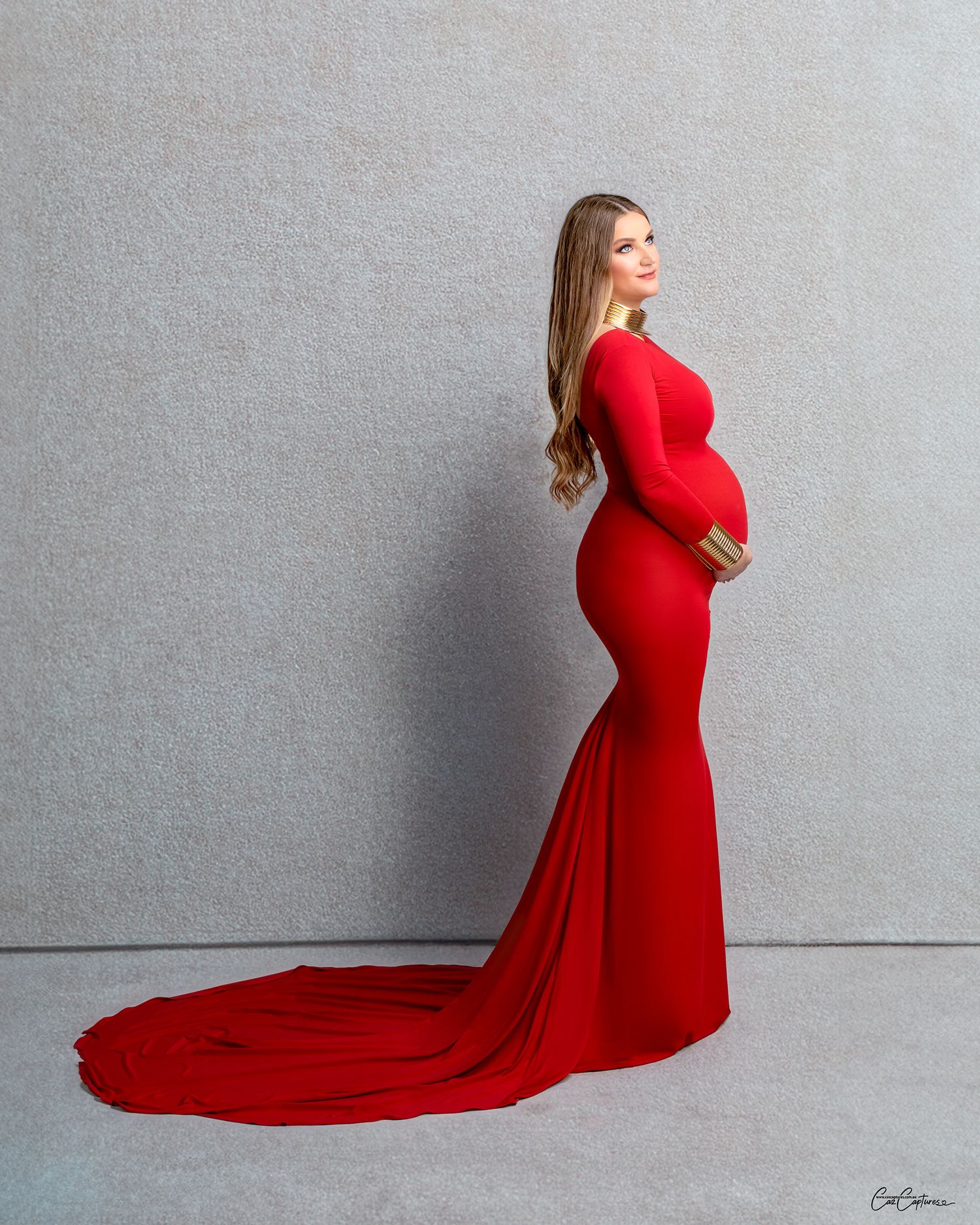 Woman in a red dress, standing strong and beautiful in Caz Captures' studio.