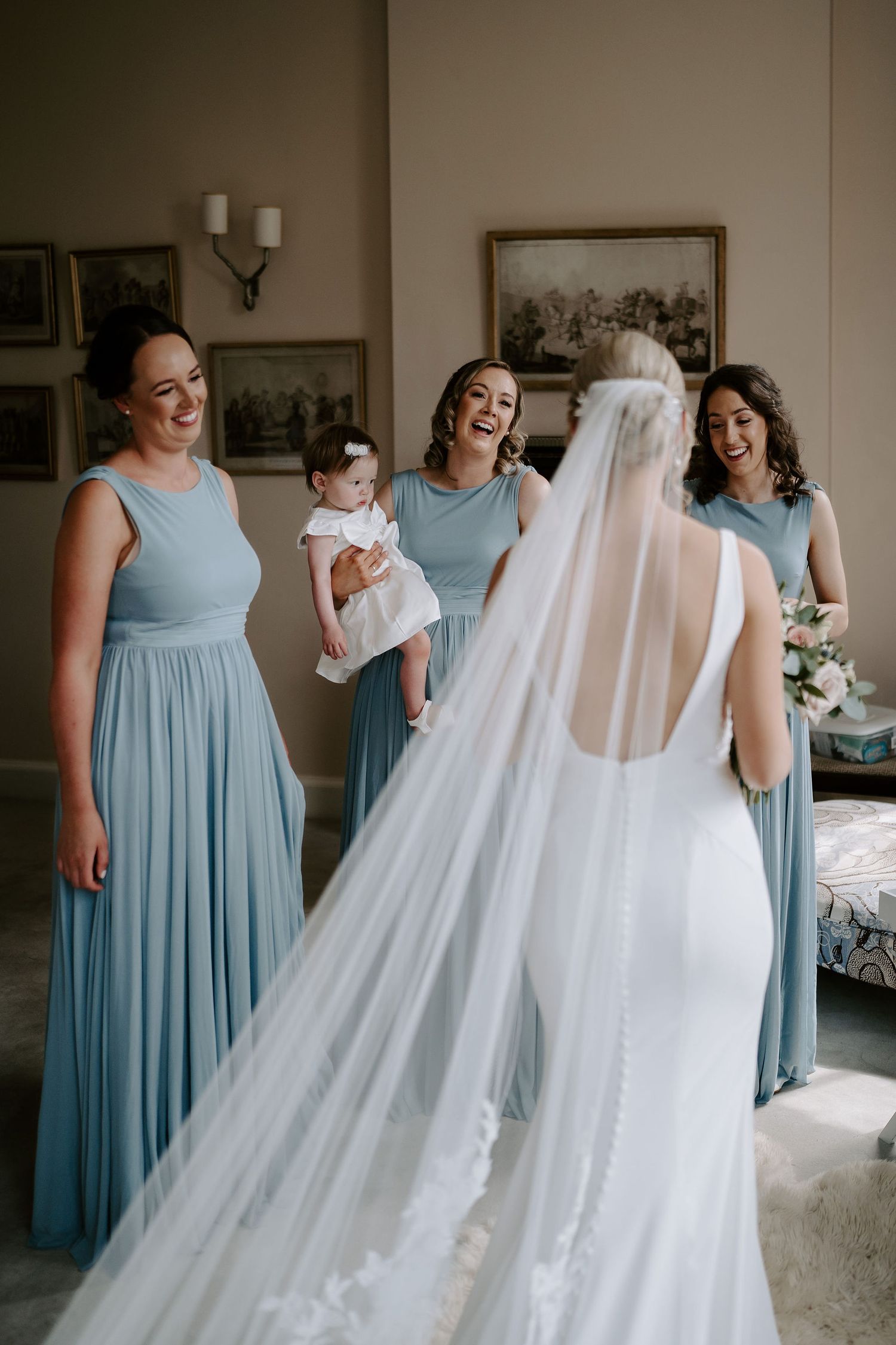 bridesmaids smiling and admiring bride and her dress at Iscoyd park