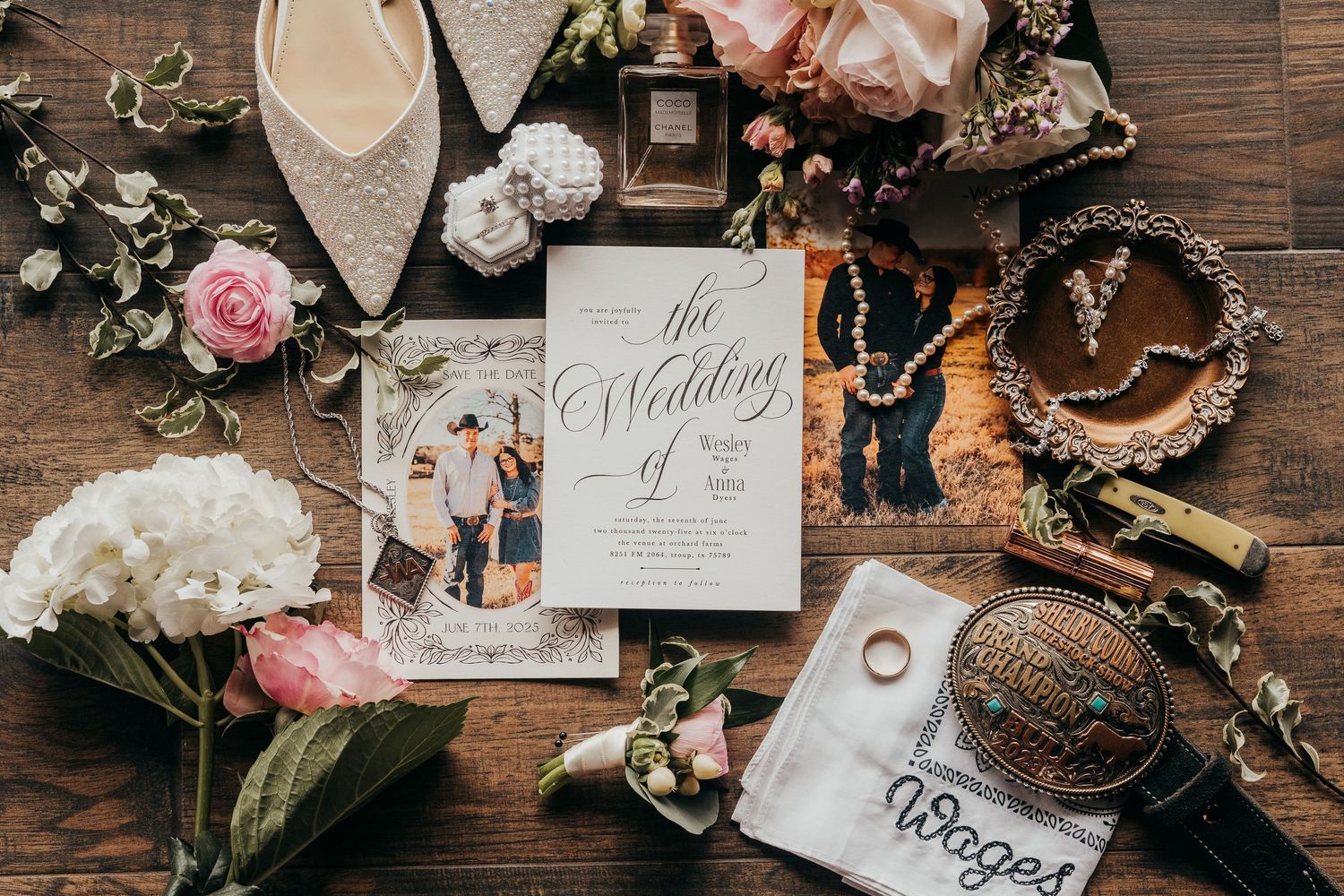 Wedding details including rings, invitations, flowers, and decor arranged on rustic wooden background.