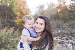 Outdoor family photo session showing candid moments between mother and child in autumn setting.