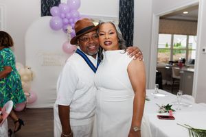 A joyous celebration with balloon decor and elegant white attire.