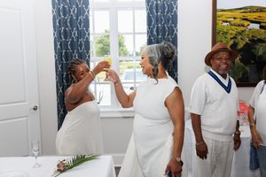 A celebratory moment at an elegant party with blue curtains and window views.