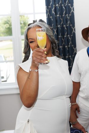 A toast with a mimosa glass at an elegant celebration.