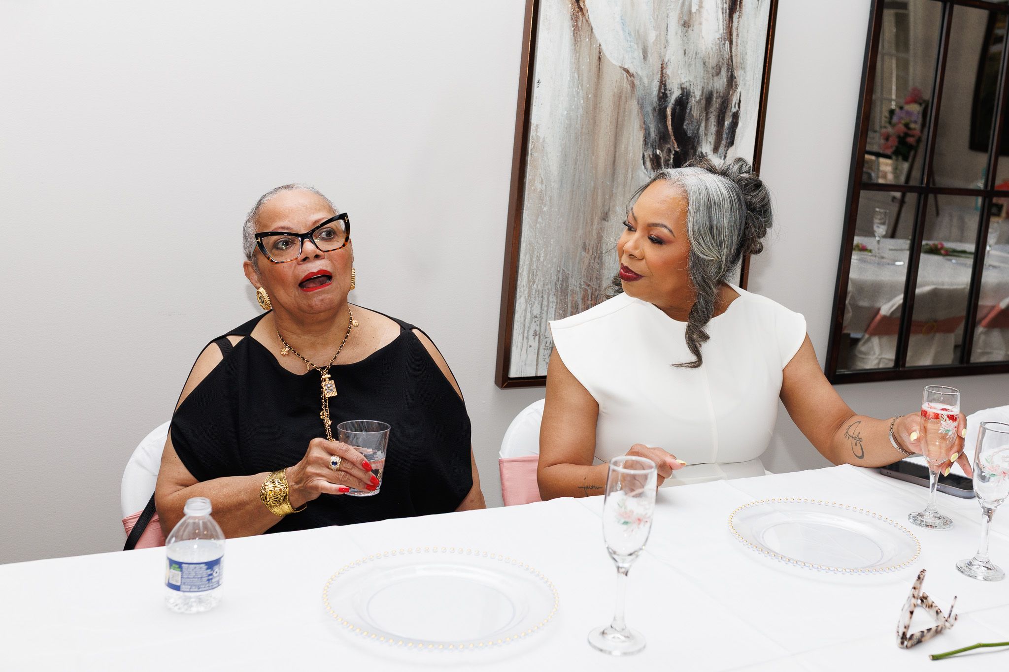 Friends sharing laughter during a formal dining event.
