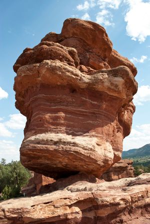 Balanced Rock formation stands precariously against blue sky at Garden of the Gods park in Colorado Springs.